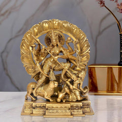 Brass Durga idol with ten arms, ornate halo and weapons, mounted on pedestal