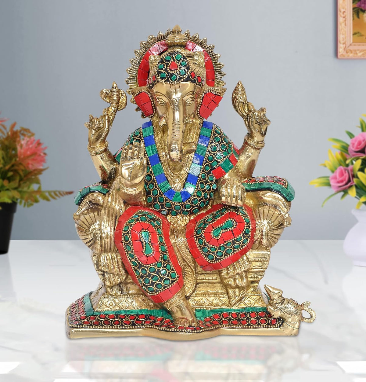 Brass Ganesha idol sitting with jeweled red, teal, and gold crown and four raised arms