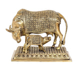 Brass Kamdhenu cow statue with calf, detailed floral pattern on body, on rectangular platform