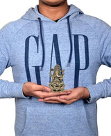 Brass Ganesha idol in hands for size scale, seated on lotus base, 3 inch