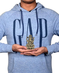 Brass Ganesha idol in hands for size scale, seated on lotus base, 3 inch