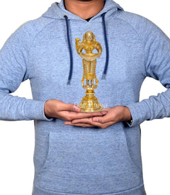 Person holding brass Deeplakshmi with parrot idol figurine on round base