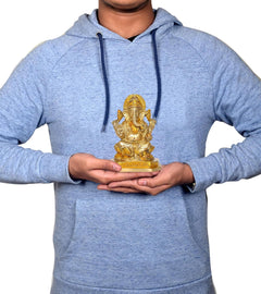 Brass Ganesha idol held in hands, small seated statue on pedestal base