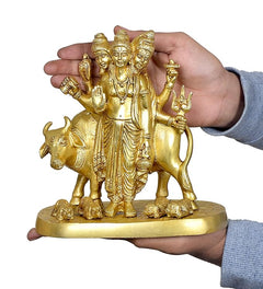 Hand-held brass Trimurti idol with auspicious cow, three deities and raised symbols
