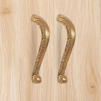 Golden brass main door pull handle pair with decorative floral engravings.