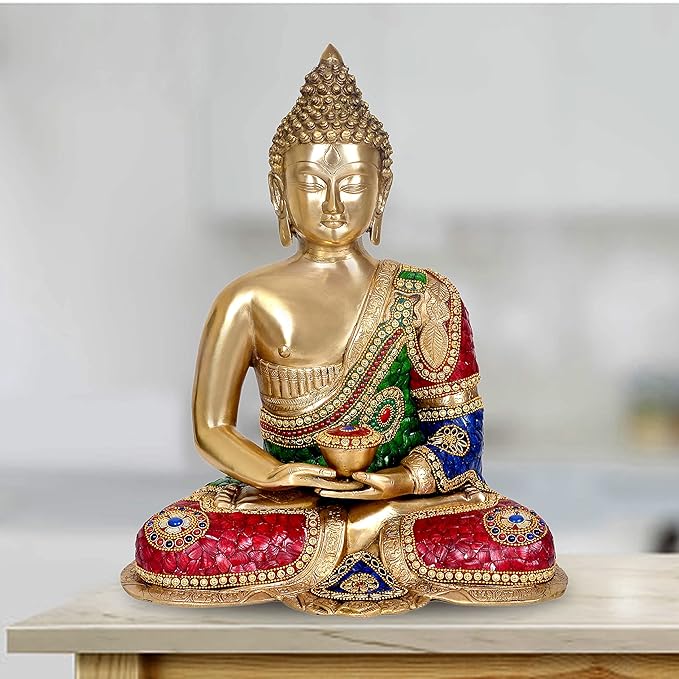 Gold brass Buddha meditation idol seated cross-legged, closed eyes and jeweled multicolor robe.