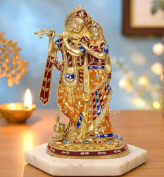 Radha-Krishna idol standing on round base, orange and blue attire with gold detailing