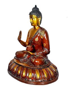 Brass seated Buddha idol, side profile, raised hand and lap bowl, lotus base