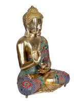 Brass Buddha statue seated with Abhaya mudra, front three-quarter view, multicolor patterned robe