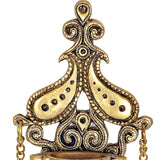 Brass diya close-up: ornate peacock-style crest above the oil bowl, chain detail