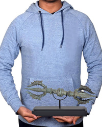 Bronze eight-pronged Dorje on wooden base held by person, turquoise patina