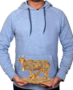 Kamdhenu cow and calf metal showpiece held in hands, gold ornate detailing and bell
