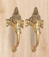 Brass Ganesha face door handle pair with detailed headgear and curved pull levers