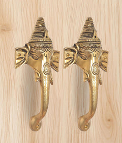 Brass Ganesha face door handle pair with detailed headgear and curved pull levers