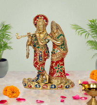 Brass Radha Krishna statue idol with jeweled red and green outfits, holding a flute