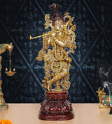 Lord Krishna brass flute idol with detailed ornaments, dark red pedestal base