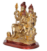 Brass Shiva family idol from side view, four seated figures holding tridents and staffs