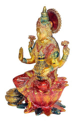 Lakshmi idol figurine from side view, red sari, gold details, seated on lotus base