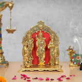 Metal Ram Darbar statue: three seated figures under golden arch with red backdrop
