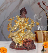 Maa Saraswati statue dorada con sitar, base roja y figura con corona