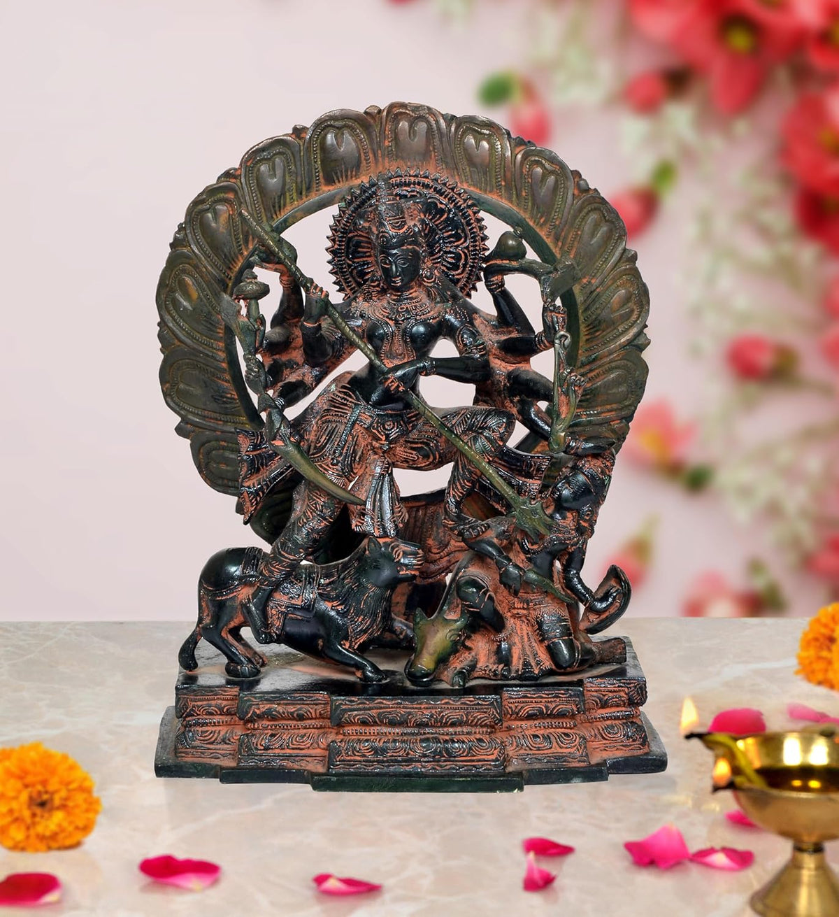 Brass Durga Maa idol with many arms, riding lion, ornate circular halo, on base