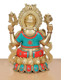 Back view of brass Ganesha statue with ornate crown, teal-red outfit, and raised arms