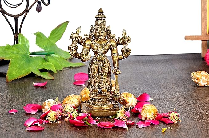 Brass Lord Vishnu idol on pedestal with flower petals and leaves