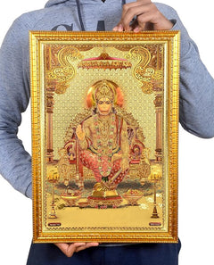 Framed Hanuman print held up, ornate golden frame and radiant halo over deity