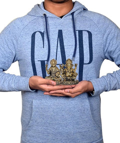 Person holding 3 inch brass Lakshmi and Ganesh idol statue for pooja