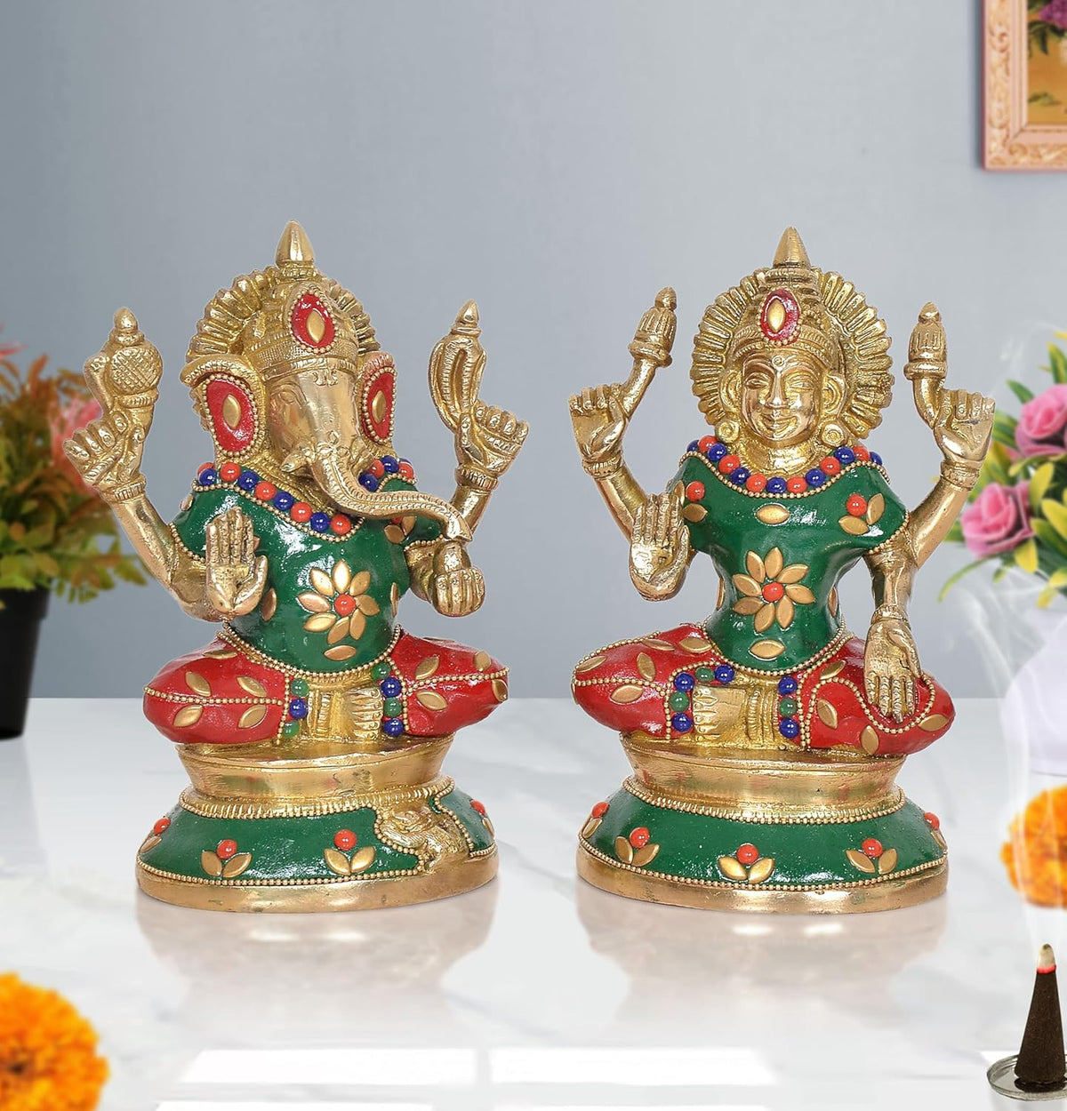 Brass Lakshmi-Ganesh idol pair: Ganesha with green robe, red accents, raised hands