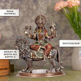 Multicolour Durga statue seated on lion with crown, jewelry, and raised weapons