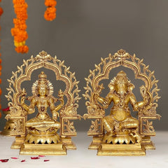 Brass Lakshmi and Ganesha statues with ornate frame, seated poses