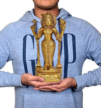 Golden brass Dhanvantri idol held in hands, detailed base visible