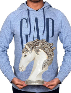 White polyresin horse head decor held in hands, gray hoodie visible behind