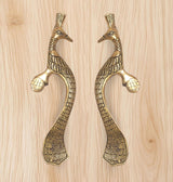 Gold peacock-shaped door handle pair with bird heads, curved bodies, and decorative grips