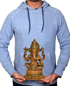 Brass Lord Ganesha idol held in hands, seated on green-and-gold lotus pedestal