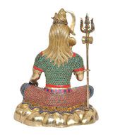 Back view of brass Shiva idol seated, trident beside, colorful stone inlay
