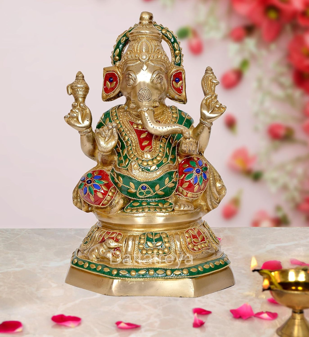 Brass Ganesha idol with colorful jewels and head adornments, four-armed pose