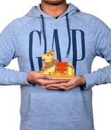 Man holding resin Nandi cow idol, yellow figure with red saddle and gold details