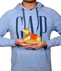 Man holding resin Nandi cow idol, yellow figure with red saddle and gold details