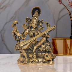 Brass Maa Saraswati statue, seated goddess holding veena, ornate detailing, golden finish