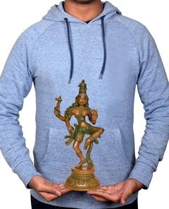 Small brass Ardhanarishvara Shiva-Parvati statue held in hands in front of hoodie
