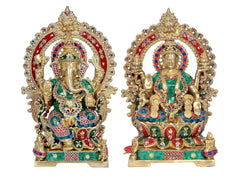 Two brass Lakshmi and Ganesh idols side-by-side, intricate painted detailing and crown