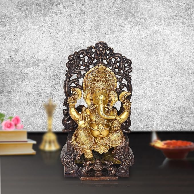 Gold Ganpati statue seated on carved singhasan throne, dark ornate backrest