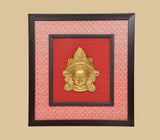 Brass Maa Durga face idol wall hanging, gold deity head relief centered on red panel