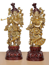 Radha Krishna brass idol pair, side-by-side figures with ornate gold attire and maroon crowns