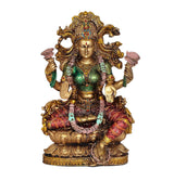 Lakshmi resin idol close-up, gold headpiece, green complexion, red patterned sari, seated