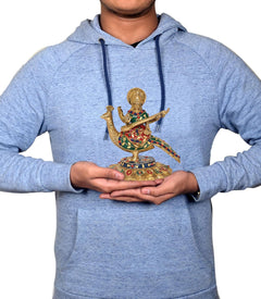 Brass Saraswati idol held in hands, veena and swan figure visible, colorful painted details.