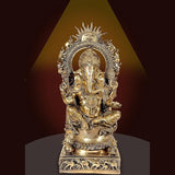 Brass Ganesha murti with ornate arch halo, seated figure on engraved base