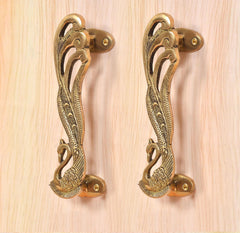 Ornate peacock brass door handle pair with oval screw plates and curved pull